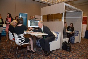 Attendees at the Maine Real Estate & Development Association (MEREDA) conference test out the "office of the future" set up by Creative Office Pavilion to augment the conversation about the same topic, keynoted by two renowned architects from the design firm Gensler who traveled from Texas to speak at the event.