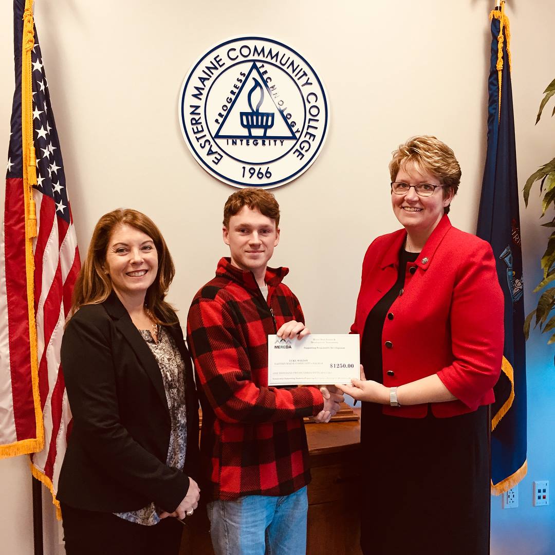 Jenn Khavari, Director of Advancement and Business Services at EMCC (left) and Bev Uhlenhake (right), Epstein Commercial Real Estate and MEREDA Board of Directors present a scholarship award to EMCC Student Luke Malloy 