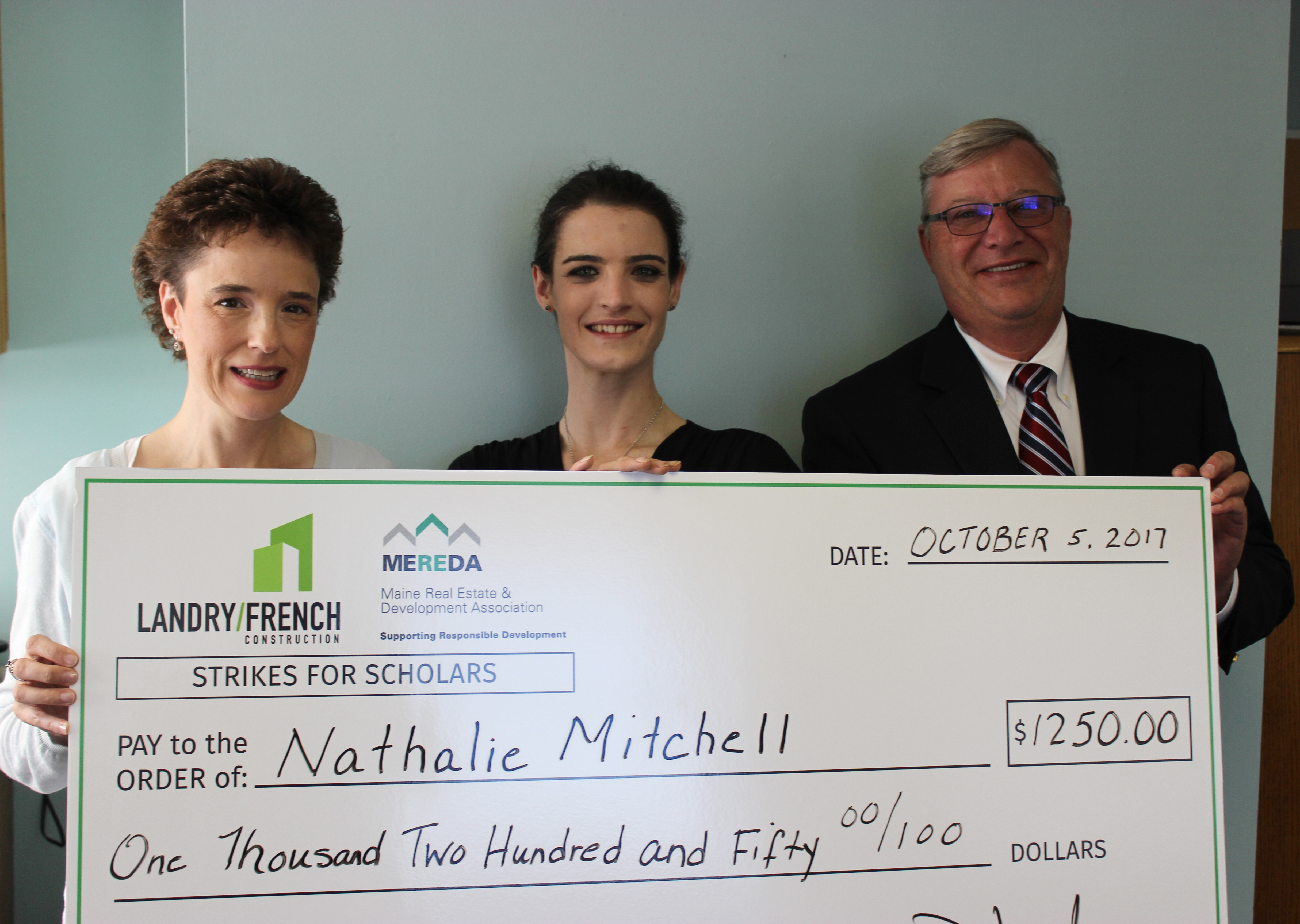 Shelly R. Clark from MEREDA and Denis Landry from Landry/French Construction present a scholarship check to SMCC Student Nathalie Mitchell. 